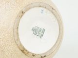 a close up of a vase on a white surface