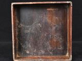 a close up of a small wooden box with a black background