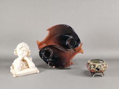 trois vases et une statue d'enfant posés sur une table