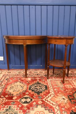 une paire de tables d'appoint anciennes en acajou posées sur un tapis devant un mur bleu