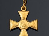 a gold cross with a medallion on it on a black background