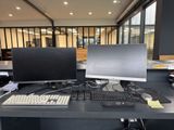 two computer monitors and a keyboard on a desk
