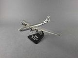 silver model of an airplane on a black stand on a gray surface
