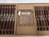 many forks and spoons in a box on the table