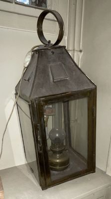 a small lantern sitting on top of a white shelf