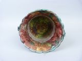 underside view of a green and red vase on a white surface