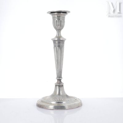 une bougie en argent posée sur une table