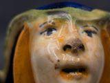 a ceramic figurine of a woman with a hat on her head