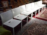 Plusieurs chaises blanches sont alignées en rangée dans une pièce