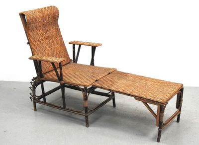 une chaise longue en osier avec une table en dessous