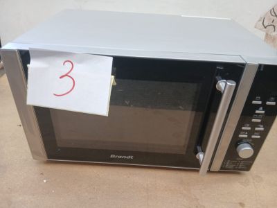 un micro-ondes sur lequel est collée une note