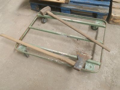 un chariot sur lequel est posé un marteau, dans un entrepôt