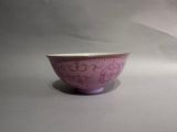 a purple bowl sitting on top of a white table