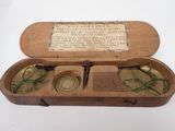 une petite boîte en bois contenant une paire de lunettes
