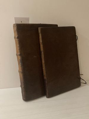 deux vieux livres posés sur une table blanche