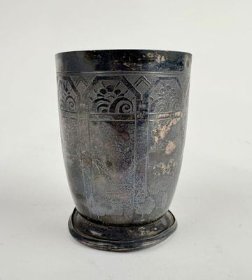 a silver cup that is sitting on a white surface