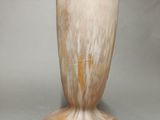 a white vase with a brown base on a table