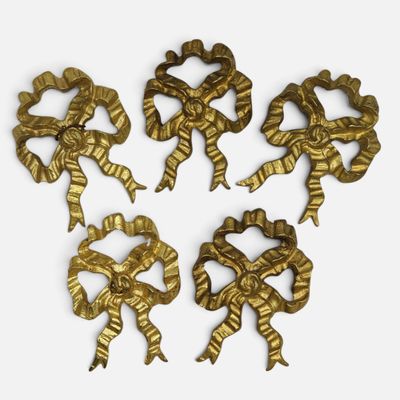 four gold metal bows are arranged on top of each other