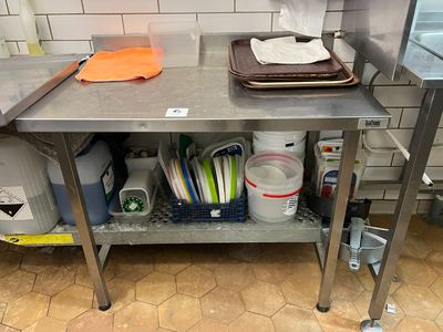 une table de travail en acier inoxydable sur laquelle sont posés tout un tas de plats