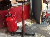 un extincteur rouge posé à côté d'une pile de bois