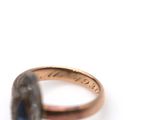 a close up of a ring with a blue stone in it