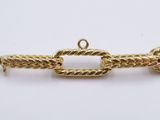 a close up of a gold chain on a white surface