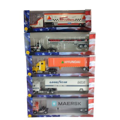 quatre camions miniatures dans une vitrine sur fond blanc