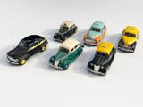 plusieurs petites voitures sont alignées sur une surface blanche