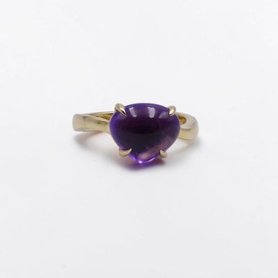gros plan d'un anneau de pierre violette sur une surface blanche