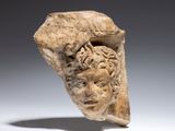 a close up of a sculpture of a head on a white surface