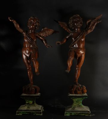 une paire de statues antiques en bronze représentant des chérubins, posées sur des socles en marbre
