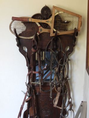 un support en bois sur lequel sont posées plusieurs vieilles raquettes de tennis