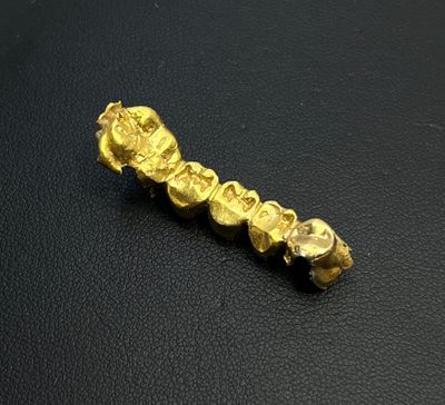 a close up of a piece of gold on a black surface