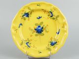a yellow plate with blue and yellow flowers on it
