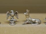 four silver figurines of animals on a table