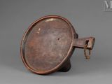 an old metal object with a wooden handle on a gray surface
