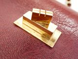 a close up of a red purse with a gold clasp