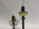 une paire de lampes à huile anciennes et une lampe en verre posée sur un pied