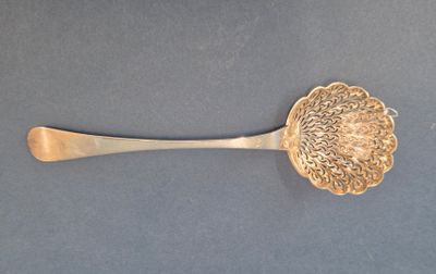 une cuillère en argent ornée d'une fleur, posée sur une table