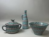 three pieces of blue and white pottery sitting on top of a table