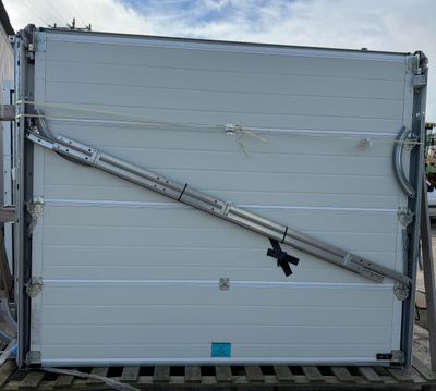 a white garage door with a metal handle on a pallet