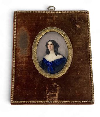 Une vieille photo d'une femme en robe bleue est accrochée au mur.