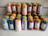 many spools of thread are arranged on a counter top