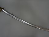 a close up of a sword on a table with a white background