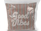 L'oreiller est dans un sac en plastique transparent sur lequel est inscrit « Good Vibe ».