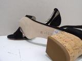pair of women ' s black shoes with cork soles on a white surface