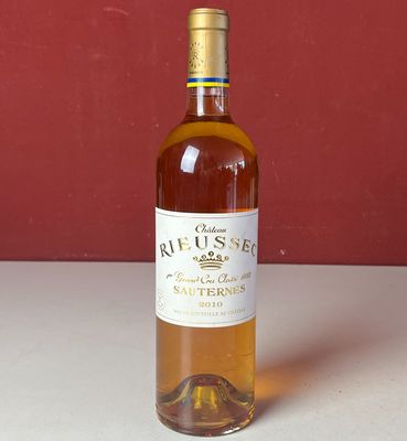 une bouteille de vin posée sur une table, à côté d'autres bouteilles de vin