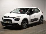 la citrole blanche est garee dans un garage au sol en damier