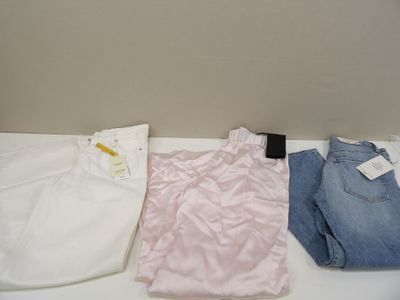 trois paires de jeans et un t-shirt posés sur une table