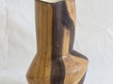 a wooden vase that is sitting on a white surface